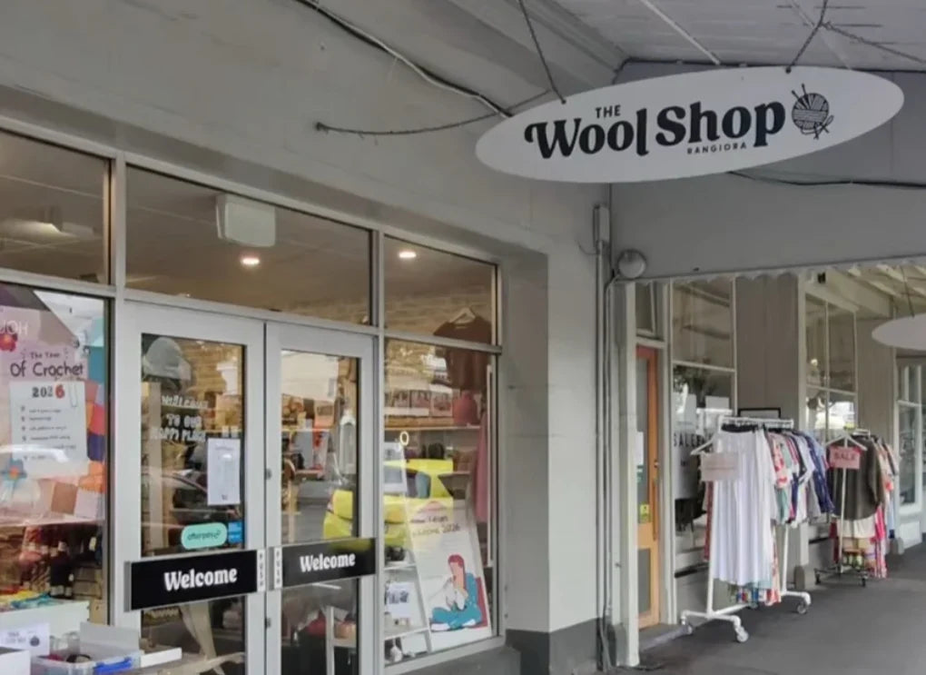 The Wool Shop Rangiora entrance with glass doors and an overhead shop sign