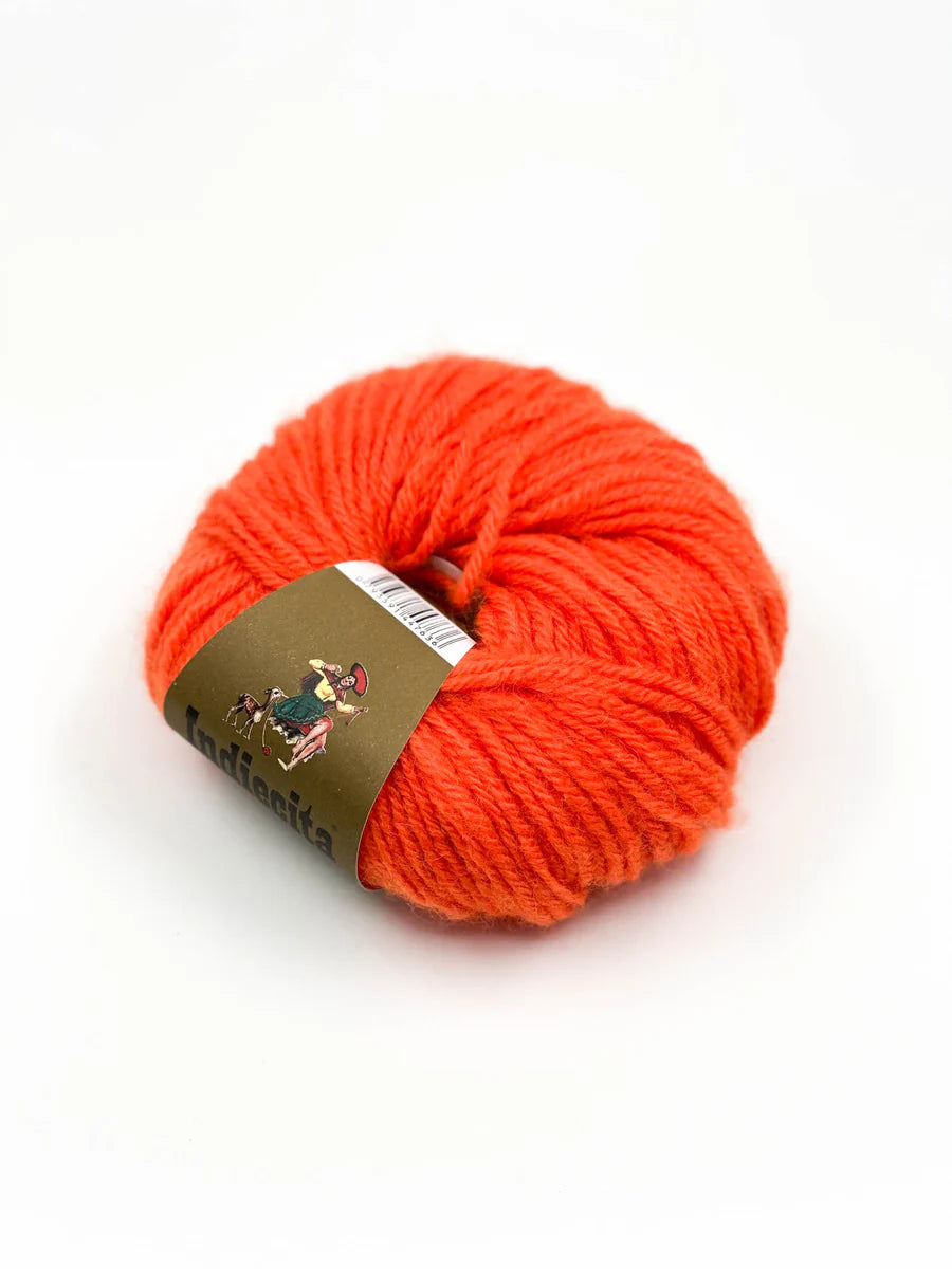 Ball of orange alpaca yarn with a label on a white background