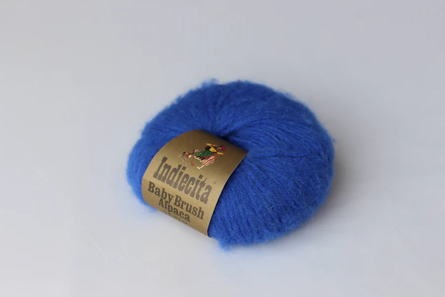 Blue skein of alpaca yarn with a label on a white background