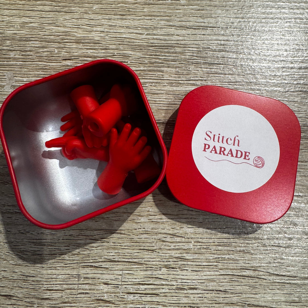 Hand shaped needle stoppers in a red tin.