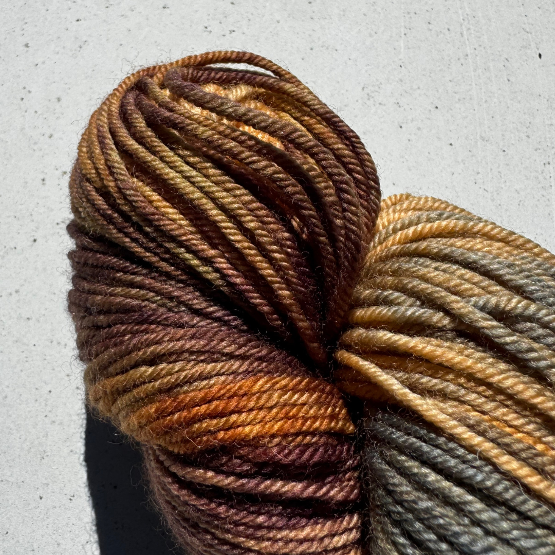 One skein of multicolored brown yarn on a textured surface