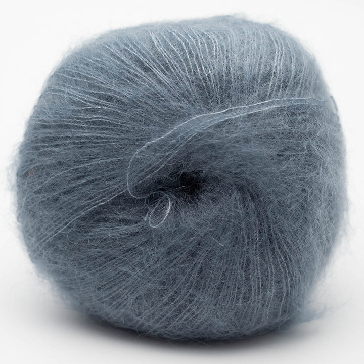 Ball of blue gray Silky Kid yarn on a white background