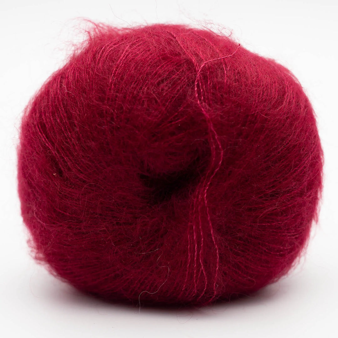 Red skein of Silky Kid yarn on a white background