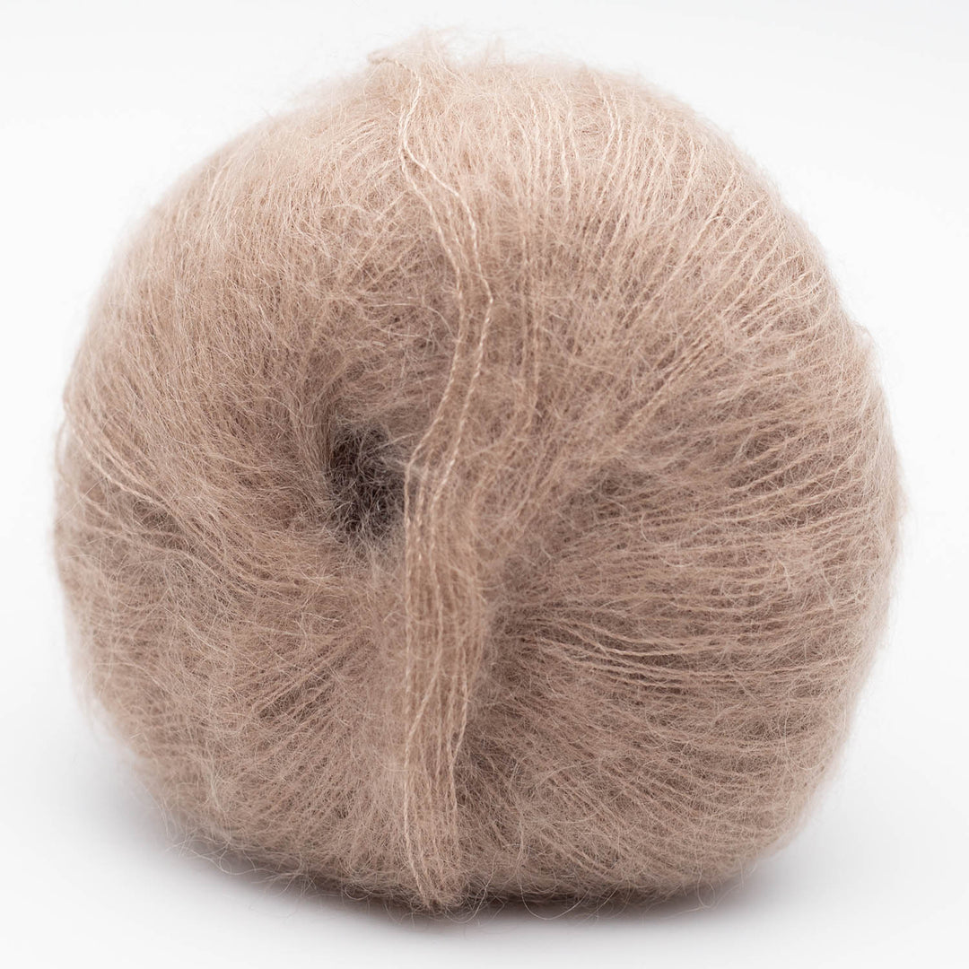 Ball of beige Silky Kid yarn in the shde camel on a white background