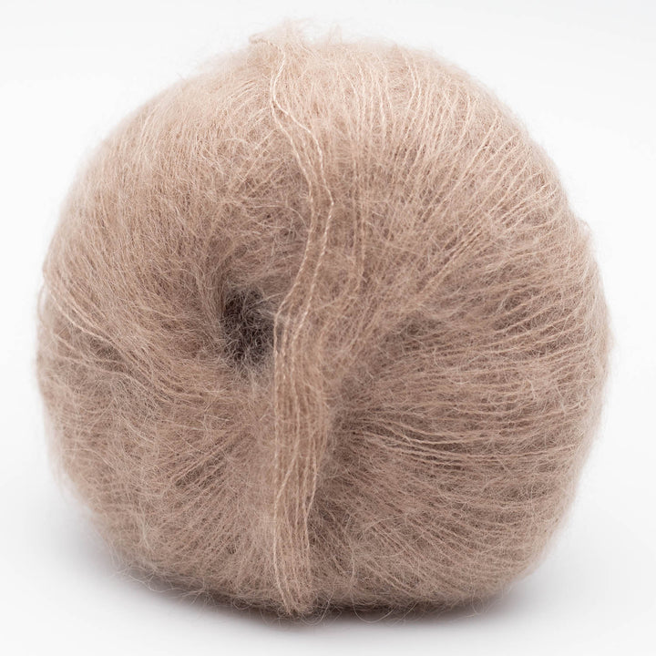 Ball of beige Silky Kid yarn in the shde camel on a white background