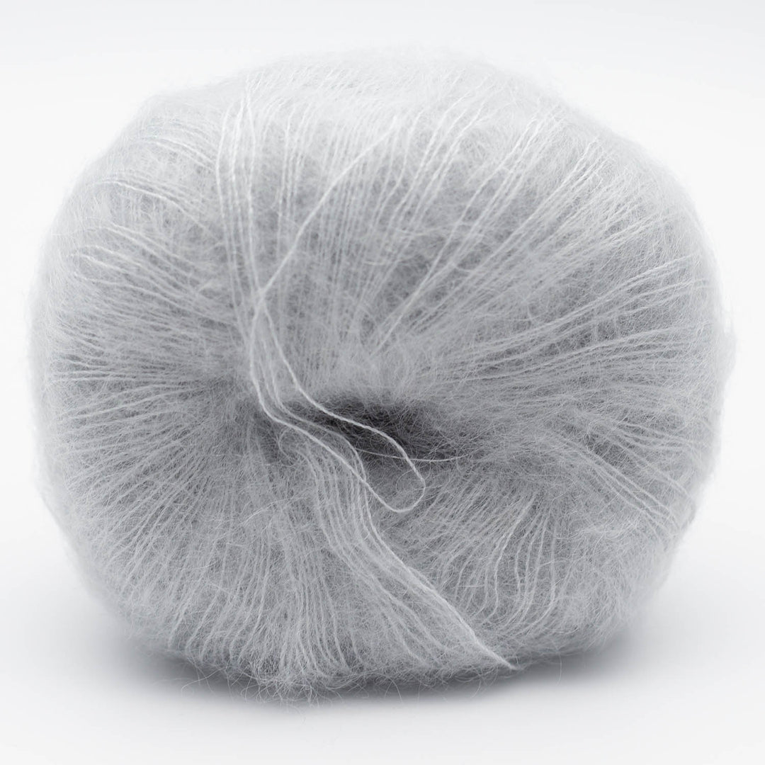 Ball of light gray Silky Kid yarn in the shade fog on a white background