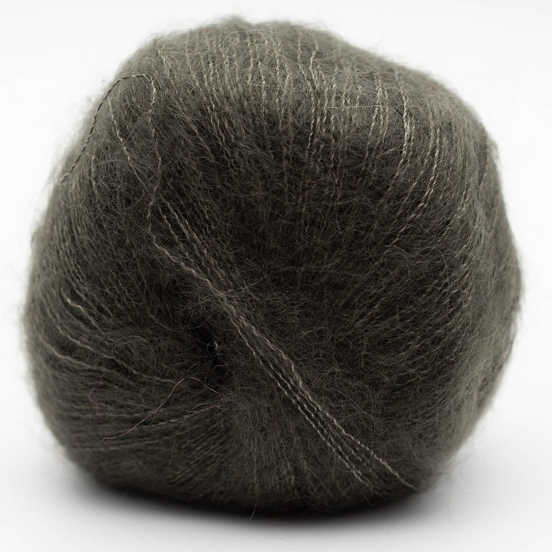 Ball of dark green gray Silky Kid yarn on a white background
