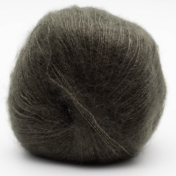Ball of dark green gray Silky Kid yarn on a white background
