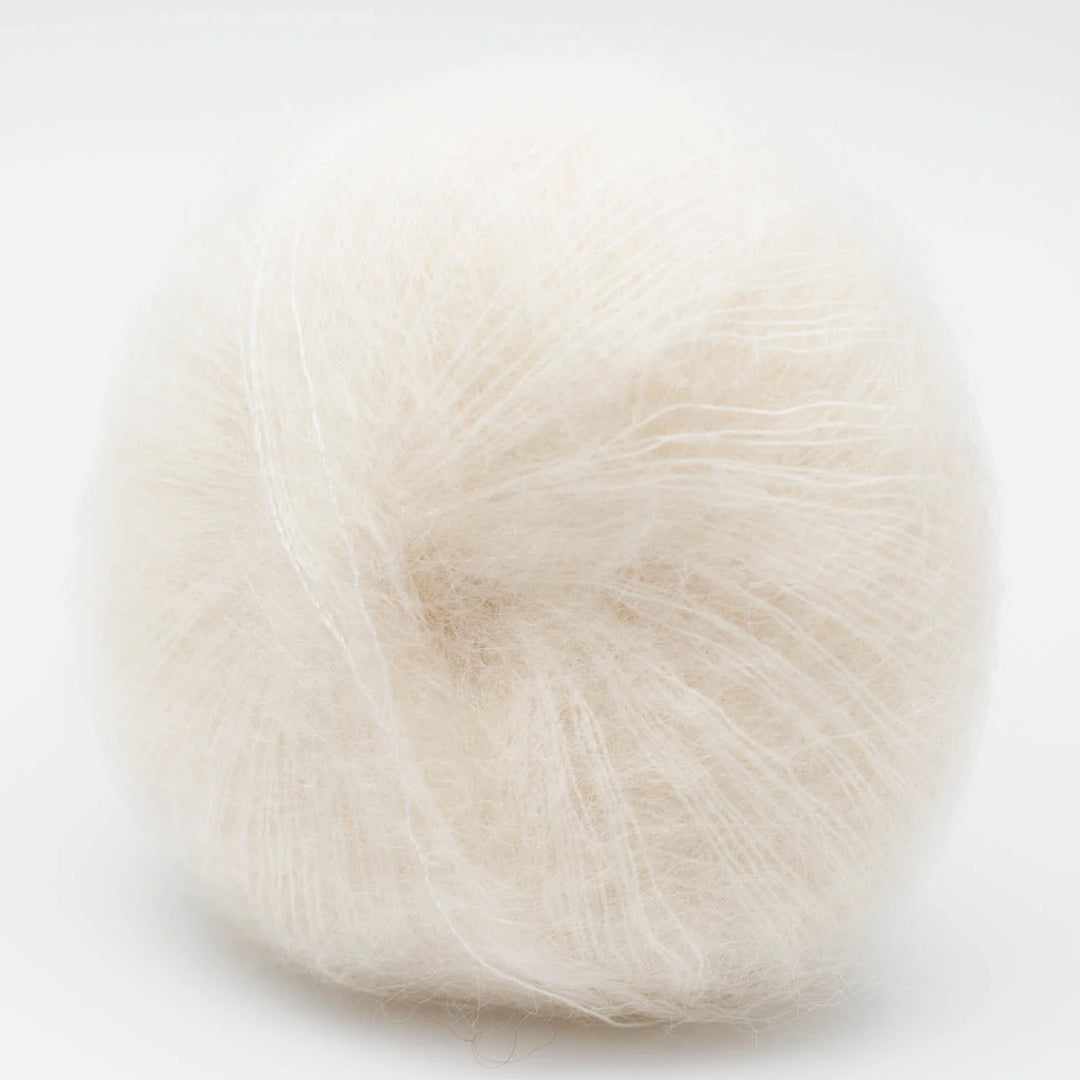 Ball of white Silky Kid yarn on a light beige background - The Wool Shop Rangiora