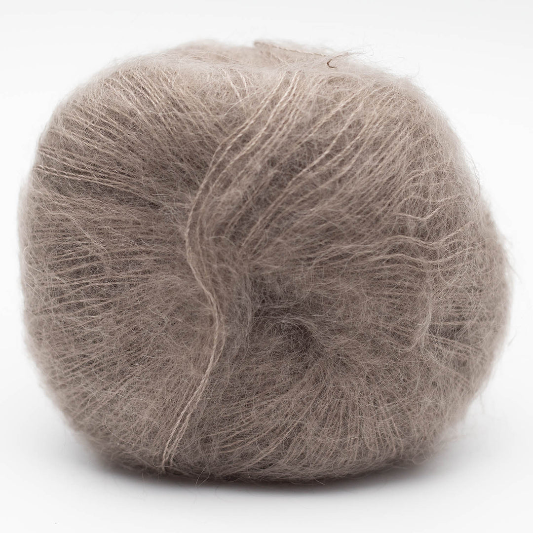 Ball of warm gray Silky Kid yarn on a white background