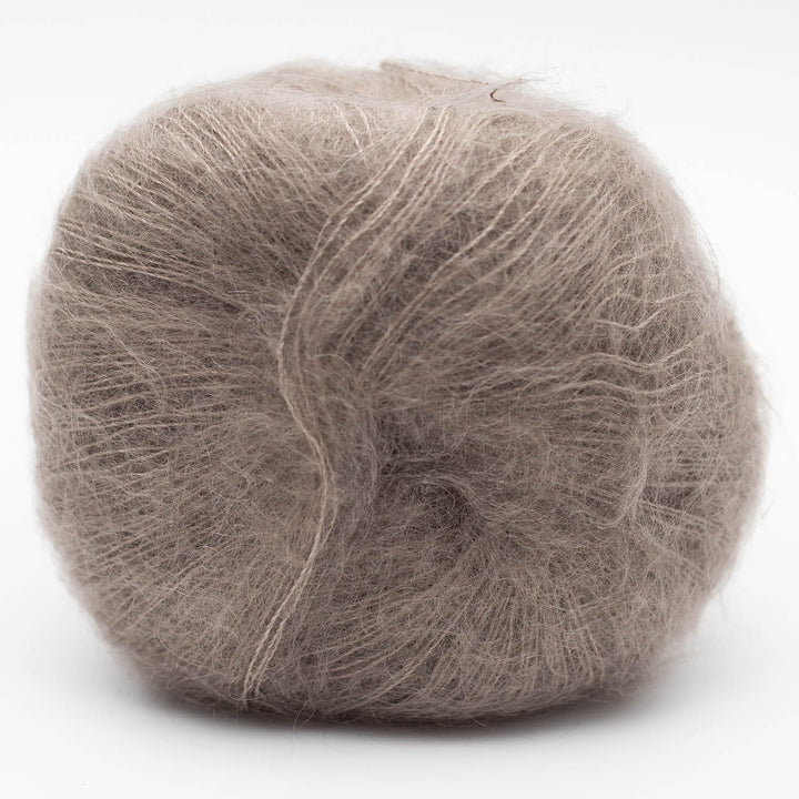 Ball of warm gray Silky Kid yarn on a white background
