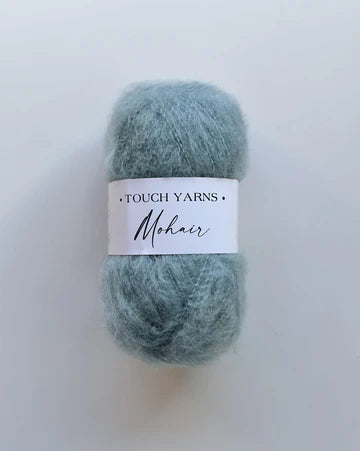 Skein of light blue Touch Yarns Mohair yarn on a white background