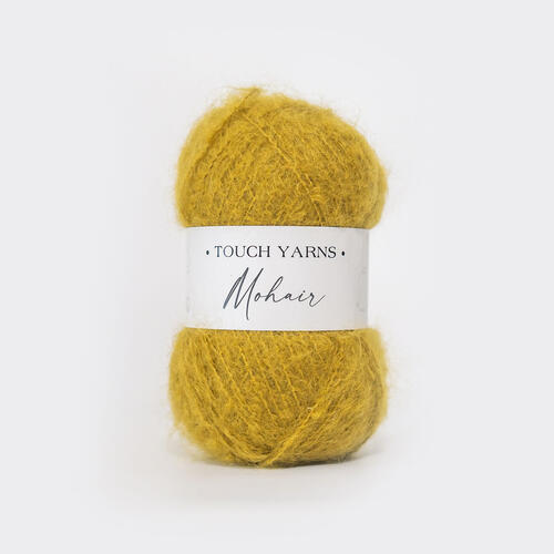 Mustard yellow yarn ball with a label on a white background