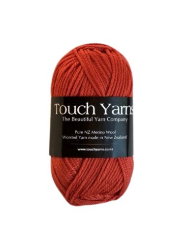 A skein of Touch Yarns Pure Merino 8ply yarn in shade spiced pumpkin, with the brand label visible.