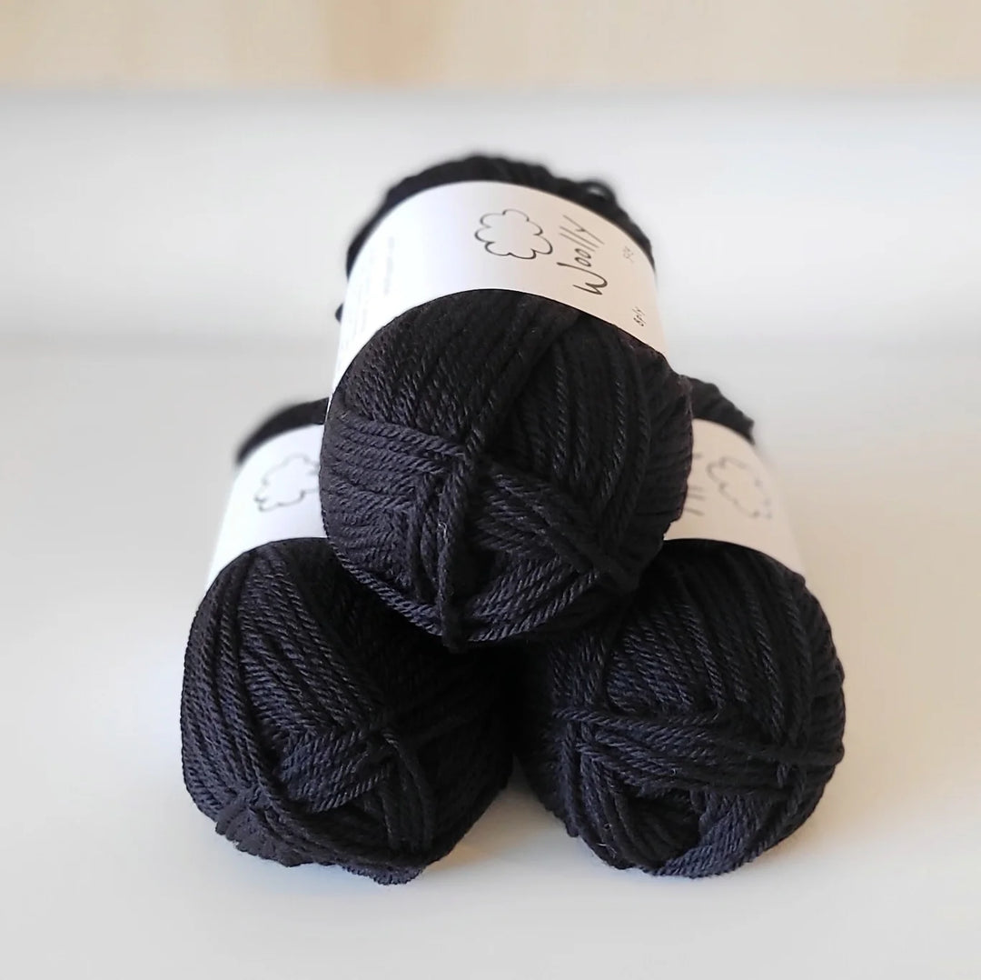 Three skeins of black yarn on a white background