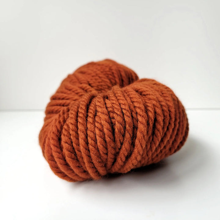 Ball of rust-colored yarn on a white background - The Wool Shop NZ