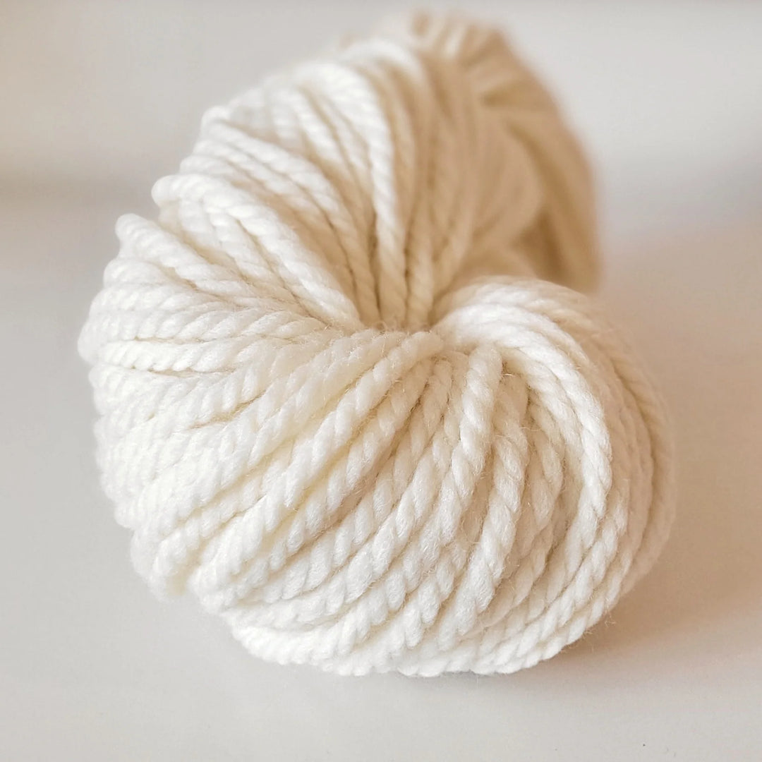 Ball of cream-colored yarn on a light background
