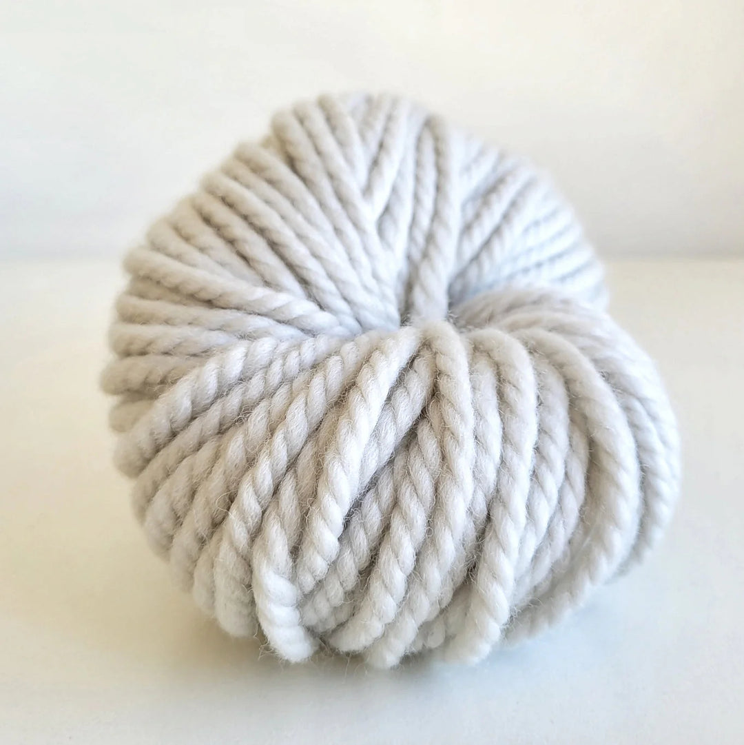 Ball of white Woolly Yarn Co Super Woolly yarn in the shade sheepish