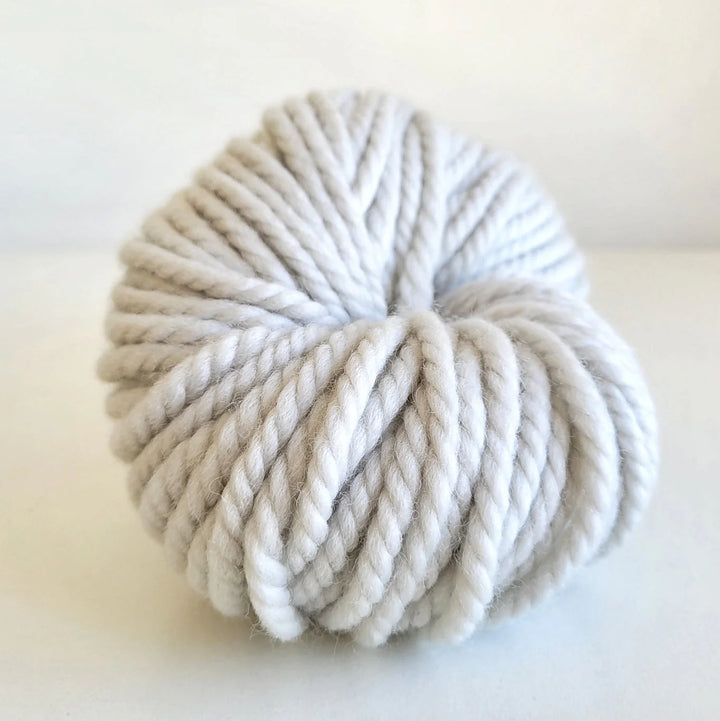 Ball of white Woolly Yarn Co Super Woolly yarn in the shade sheepish